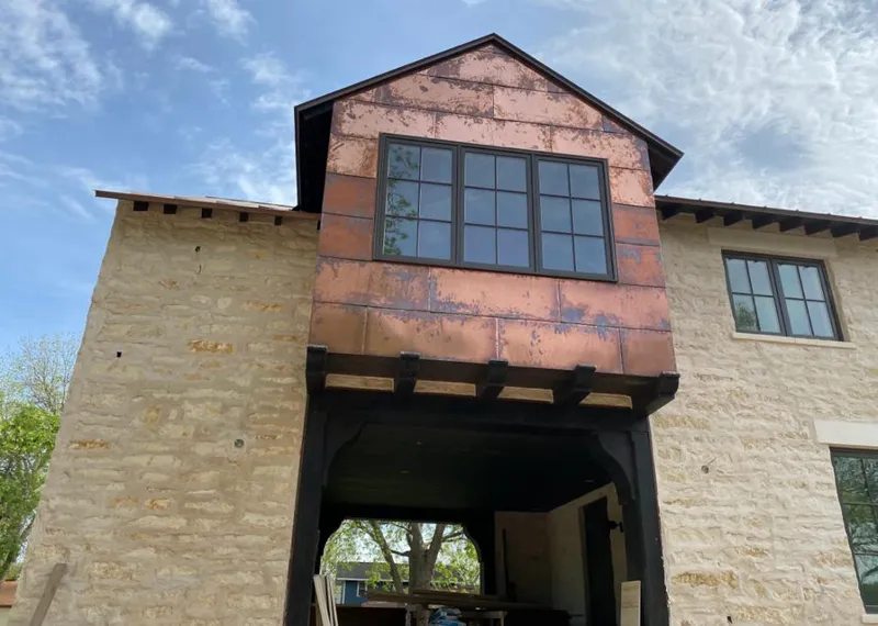 Copper metal panel facade on a stone building for Roof Repair in Jackson